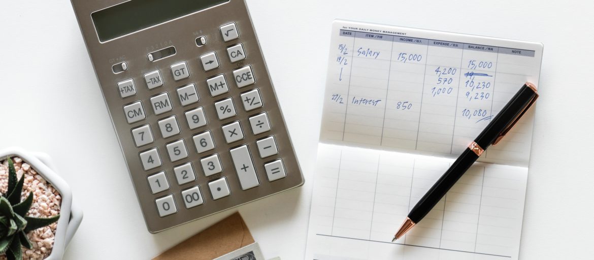 Calculator with a checkbook, pen, and money